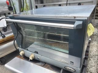 Cadco Uno-X XAF013 countertop convection oven, stainless steel with glass front, features dual dials, visible shelves inside.