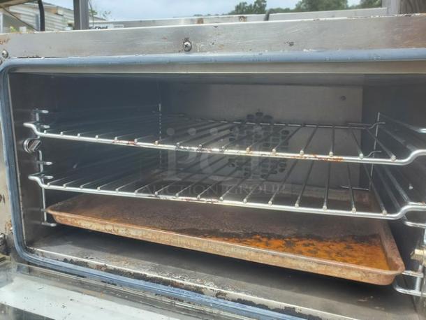 Cadco Uno-X XAF013 countertop convection oven, stainless steel, featuring two racks and a used baking tray. Moderate wear visible.