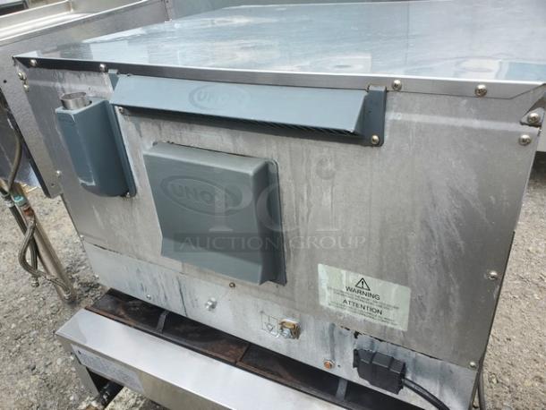 Cadco XAF013 countertop convection oven, stainless steel, labeled "Unox," with visible wear, warning sticker, and power cord.