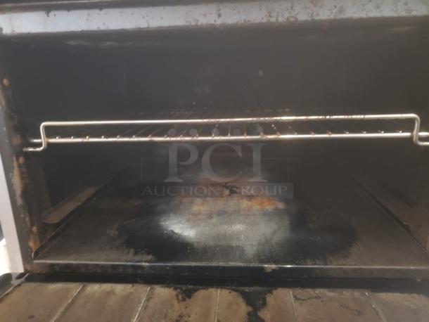 Imperial IR-6 gas restaurant range oven interior, showing rack and signs of use.