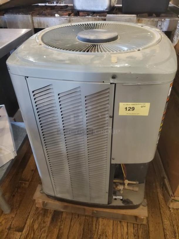 Central air conditioner condenser model 2TWB3024A1000AA; used condition with visible wear; part number tag present.