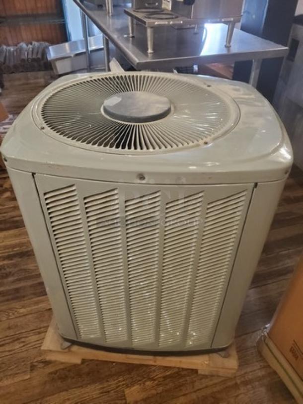 Central Air Conditioner Condenser 2TWB3024A1000AA, light gray, with visible fan and grill, in used condition.