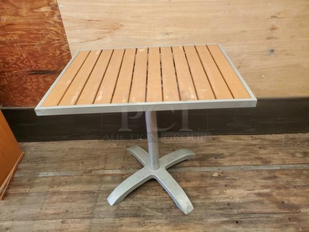 Square table with slatted wood top, metal base. Moderate wear. Ideal for indoor or patio use.