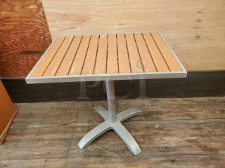 Square table top with slatted wood design and metal base, good condition. Ideal for dining or patio use.