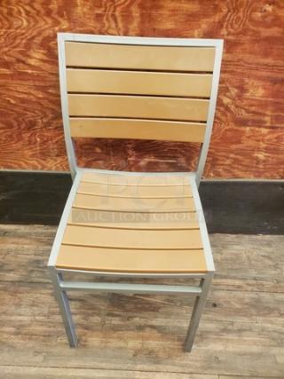 Set of 4 patio chairs with silver frames and light brown slatted backs and seats. Sturdy, modern design. Ideal for outdoor use.