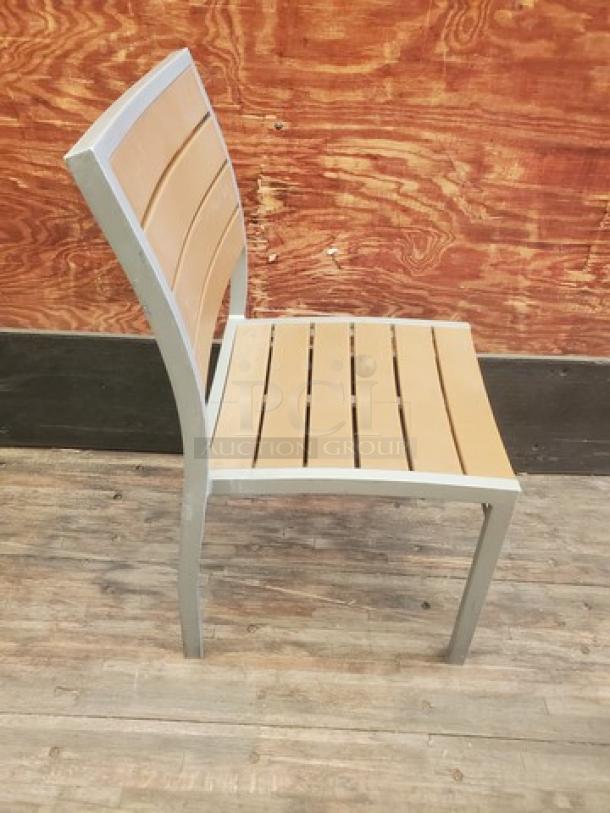 Set of four patio chairs with silver metal frames and light brown slat seats. Modern design, used condition.