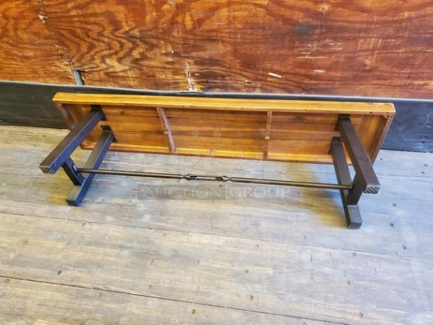 Lot of 2 wooden benches, sturdy construction with metal frame, shows minor wear. Ideal for indoor or outdoor use.
