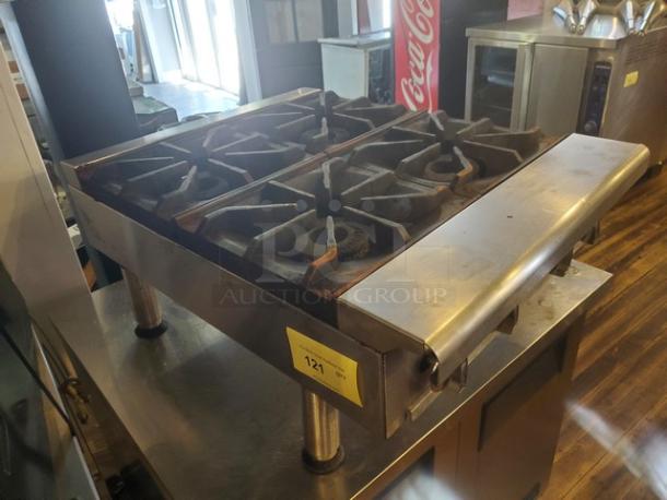 Imperial 4 Burner Range, stainless steel, used condition, sturdy cast iron grates, item tag "121."