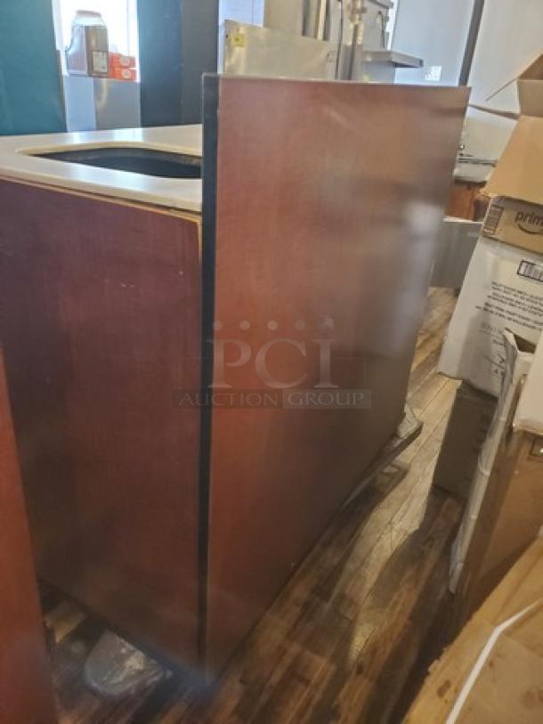 Wooden waste station with a top opening, in good condition. Suitable for commercial use. Dark wooden finish.