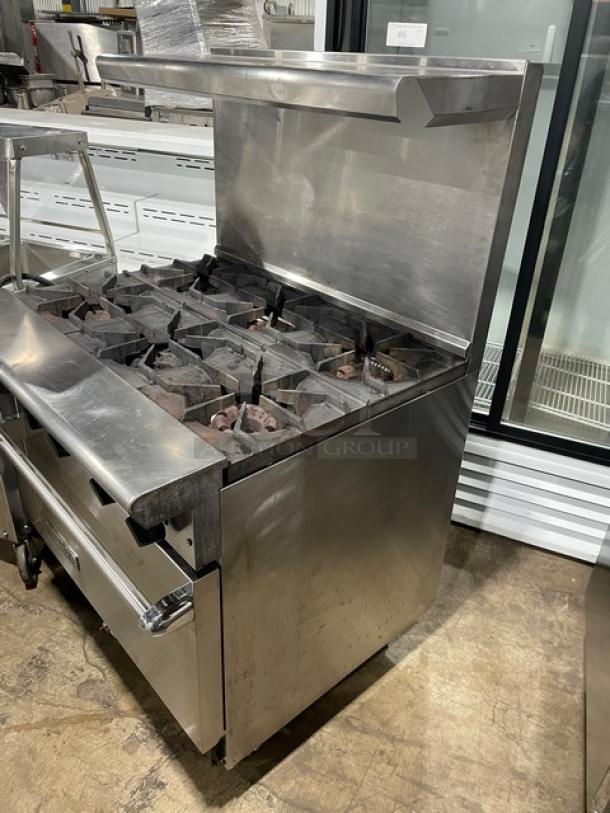 American Range commercial stainless steel 6 burner range/oven combo, natural gas, with backsplash, overhead salamander shelf, and wired oven racks on casters.