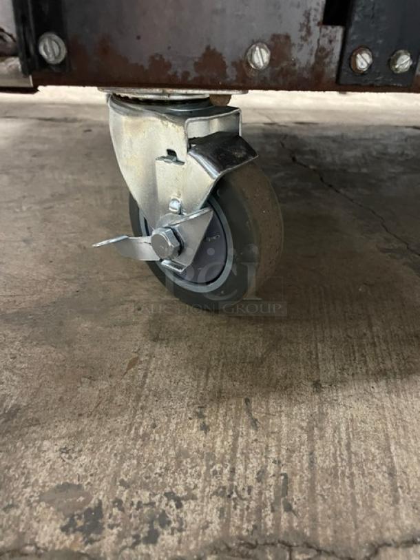 Close-up of caster wheel on an American Range commercial stainless steel gas-powered range.