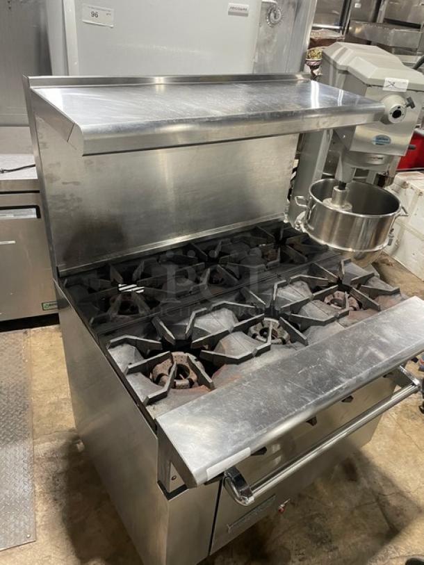 American Range stainless steel natural gas 6-burner range/oven combo with backsplash, overhead salamander shelf, and casters.