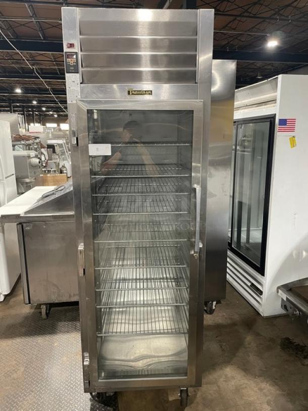 Traulsen stainless steel single glass door hot food merchandiser, model AW132N-X0001, on casters with wire racks.