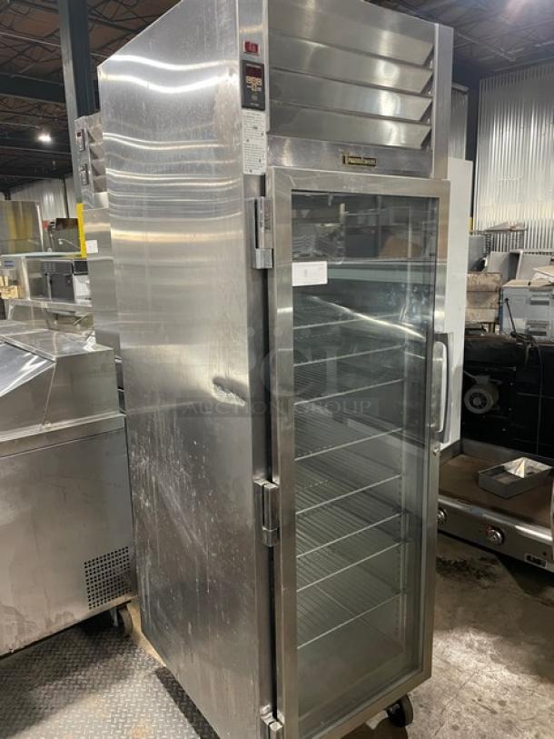 Traulsen stainless steel single glass swing door hot food merchandiser, model AW132NX0001, with wire racks and on casters.