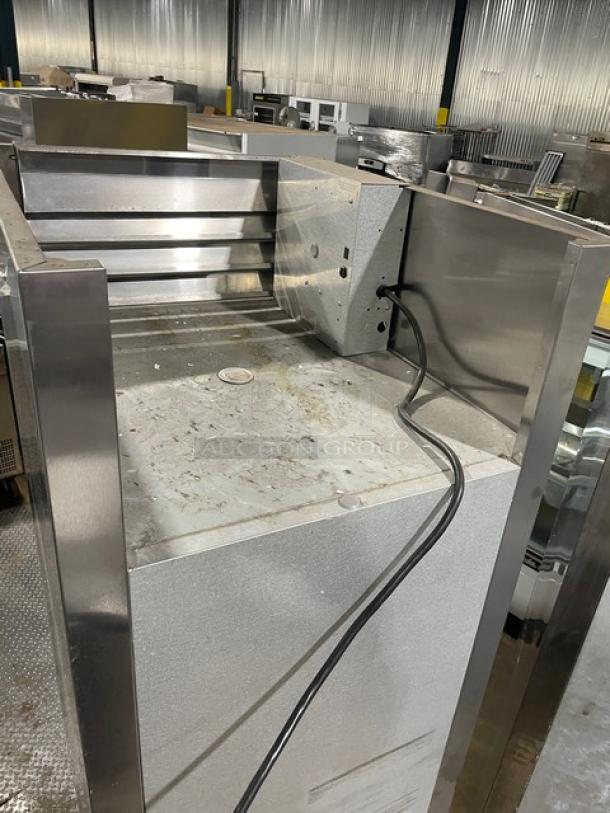 Traulsen stainless steel single glass swing door hot food merchandiser, model AW132NX0001, on casters, with wire racks.