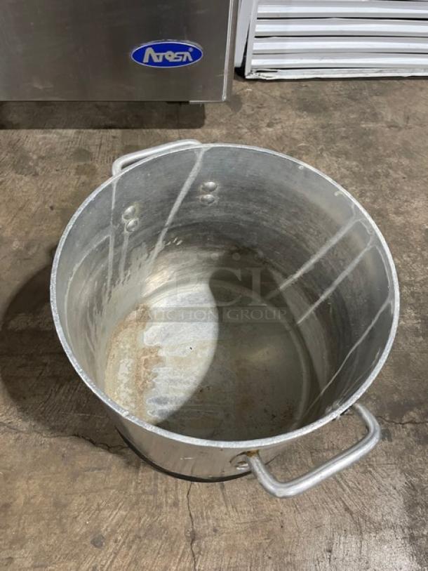 Commercial heavy duty stock pot with handles, featuring a worn interior. Ideal for professional kitchens.