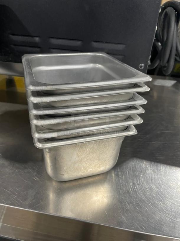 Stack of commercial stainless steel hotel/steamtable pans, used condition, reflective finish, nesting design. Auction includes six pans.