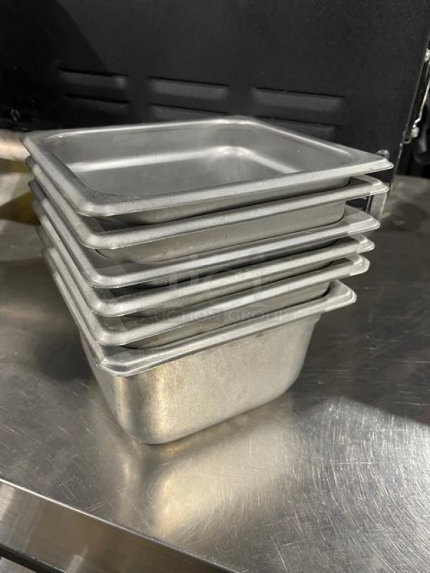 Stack of commercial stainless steel hotel/sSteamtable pans in good condition, showing six units, ideal for catering.