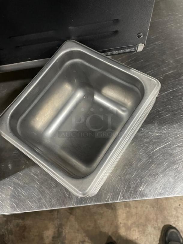 Commercial stainless steel hotel steamtable pans, stack of six, slightly used condition, visible light scratches.
