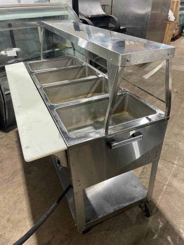 Duke Aero Hot Series EP304 stainless steel 4-well electric steam table with sneeze guard, cutting board, and undershelf on casters.