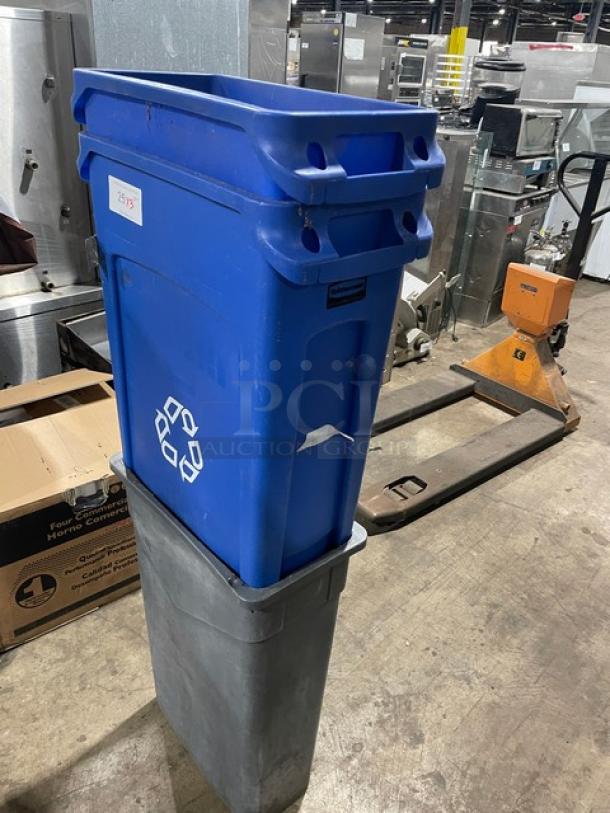 Assorted commercial blue recycle bins and a gray trash can in used condition, featuring recycling symbols and a visible label.