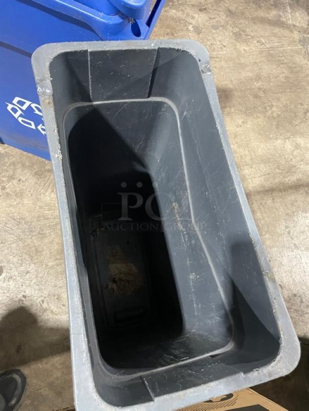 Assorted commercial blue recycle bins and a gray trash can, used condition, with visible scratches and scuffs.