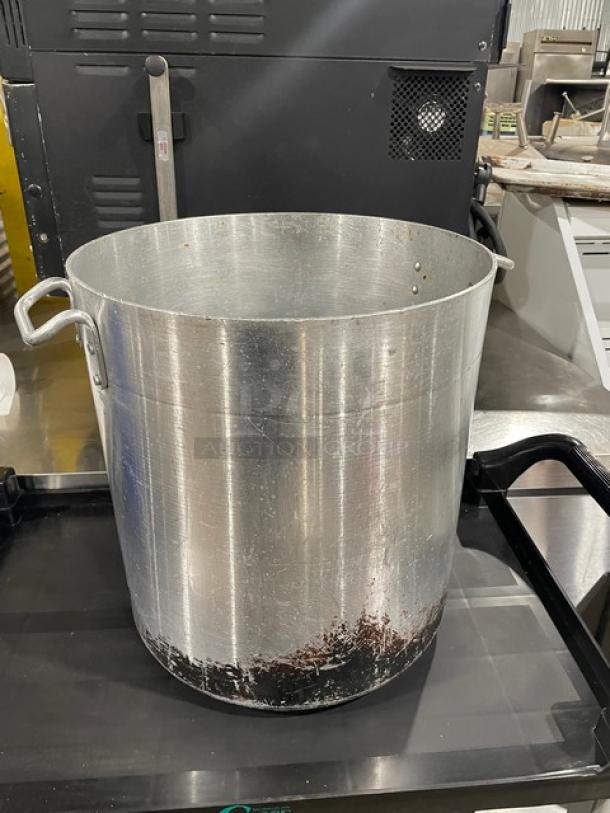 Commercial heavy-duty stock pot with handles, showing wear. Ideal for large-scale cooking.