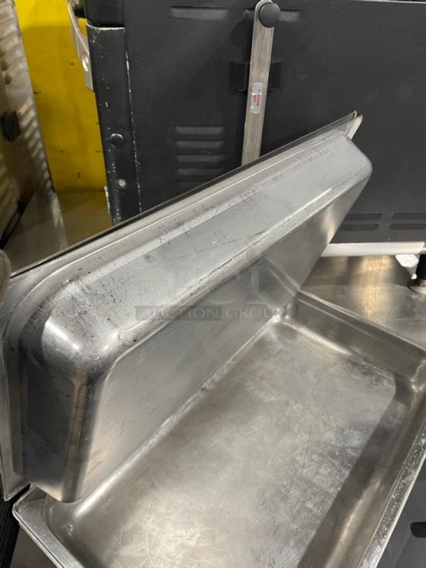 Commercial stainless steel hotel steamtable pan with lid, durable, lightly scratched, suitable for catering use.
