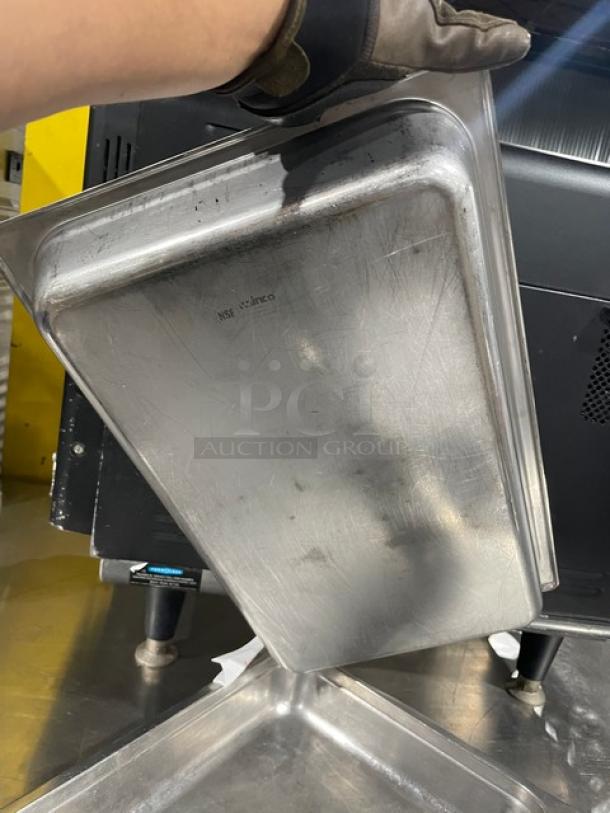 Commercial stainless steel hotel pan, used condition, visible scratches. NSF and Winco markings indicate quality standards.