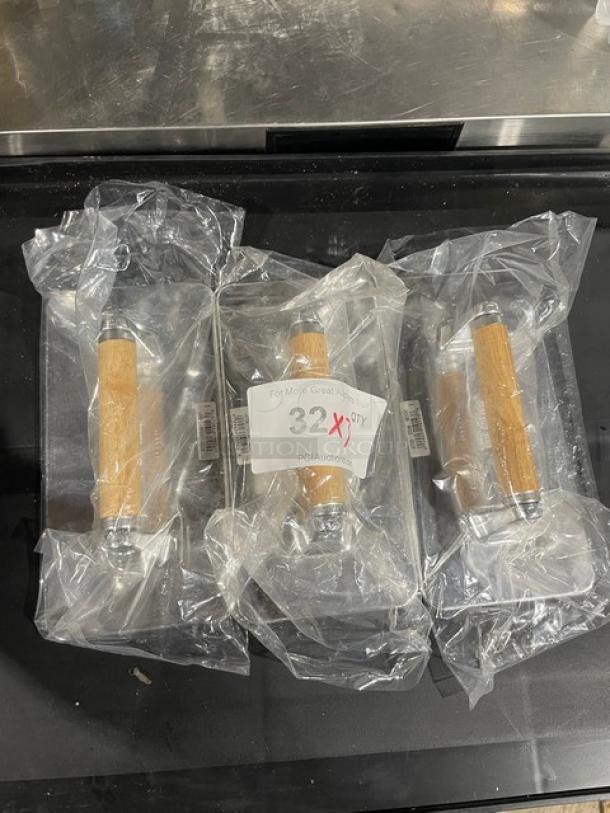 Brand new Vollrath steak weights, model 47709, with waffle-patterned cast aluminum base and wooden grip handles, packaged.