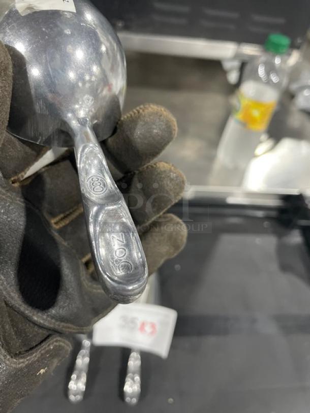 Brand new commercial cast aluminum 5 oz. scoop, model ASC-05, with markings indicating size, in pristine condition.