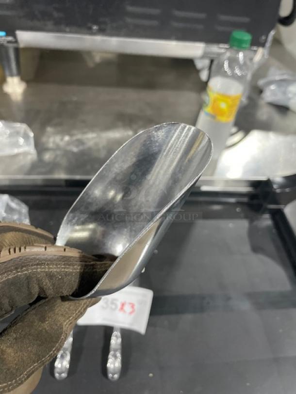 Brand new commercial cast aluminum 5 oz. scoop, Model ASC-05, held in hand. Durable and ideal for multipurpose use.