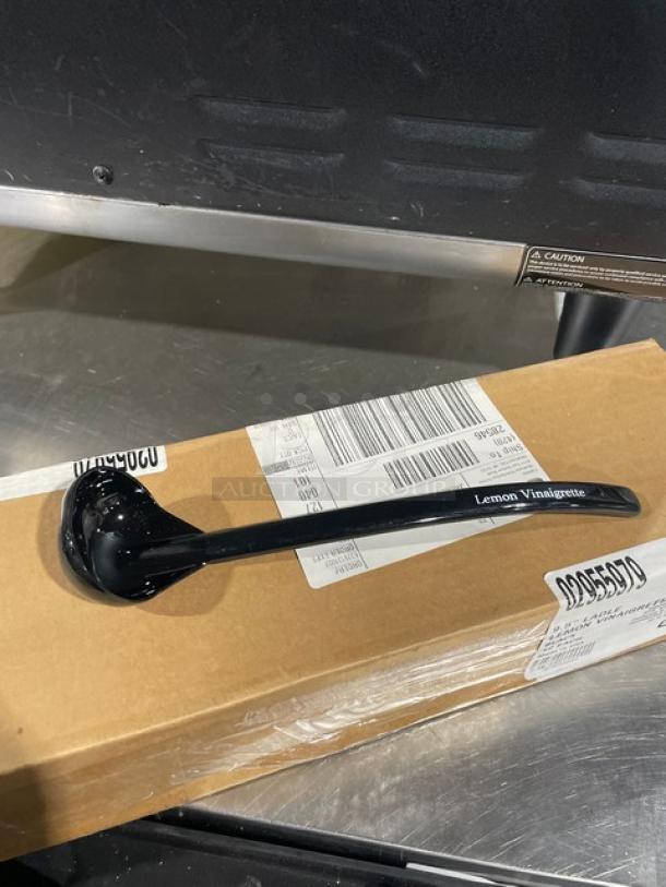 Carlisle black 9.5" lemon vinaigrette ladle, model 02955979, new with case, displayed on a cardboard box.