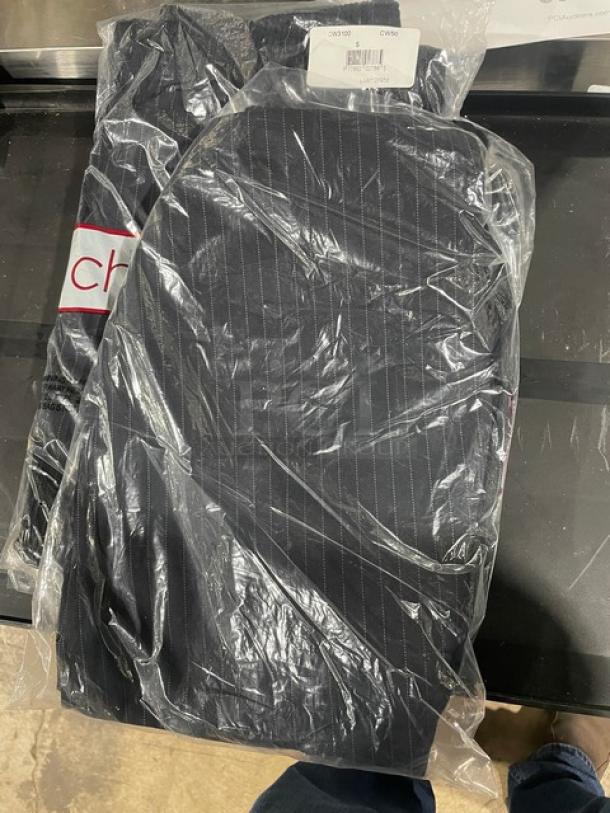 Brand new Chef Wear chef's pants in package, featuring black fabric with subtle pinstripes. Tag visible, indicating new condition.
