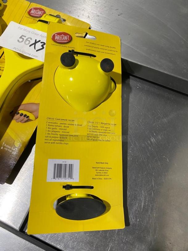 Brand new TableCraft V119 yellow handheld citrus juicer in original packaging. Model and hand wash instructions visible.