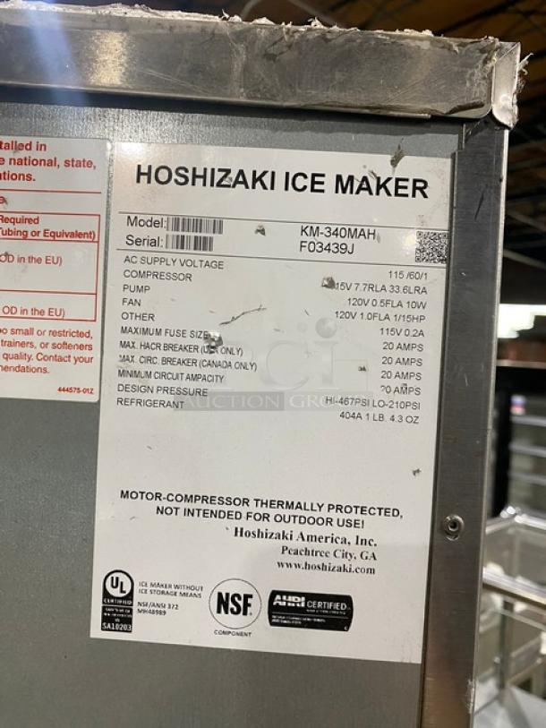 Hoshizaki ice maker model KM-340MAH/DB with label showing specs and serial F03439J. Stainless steel, 115V, on legs.