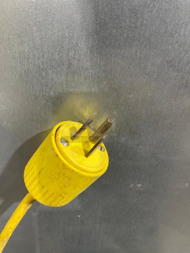 Yellow power plug for Hoshizaki KM-340MAH/DB ice maker, 115V, showing a three-prong design against a stainless steel surface.