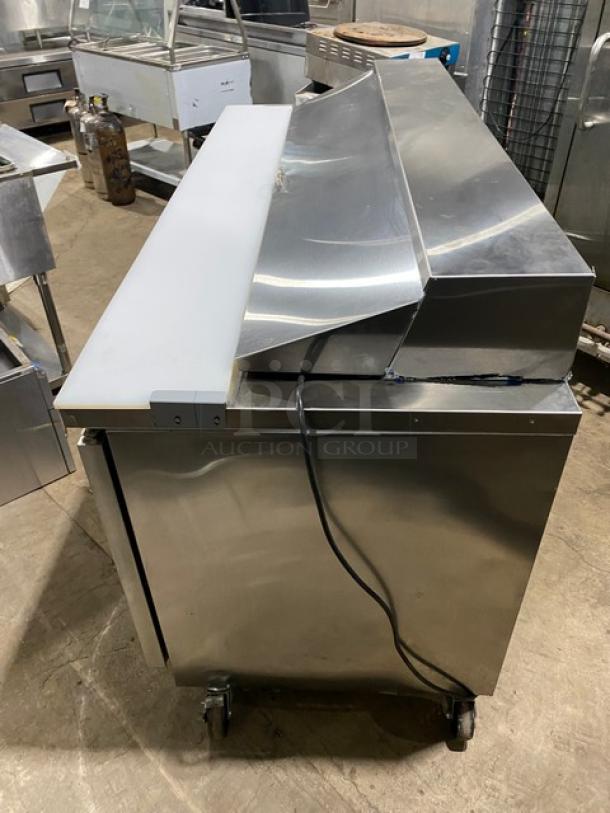 Asber APTS-72-18-HC stainless steel 3-door refrigerated prep table, 2021 model, with cutting board, wire racks, and food pans, on casters.