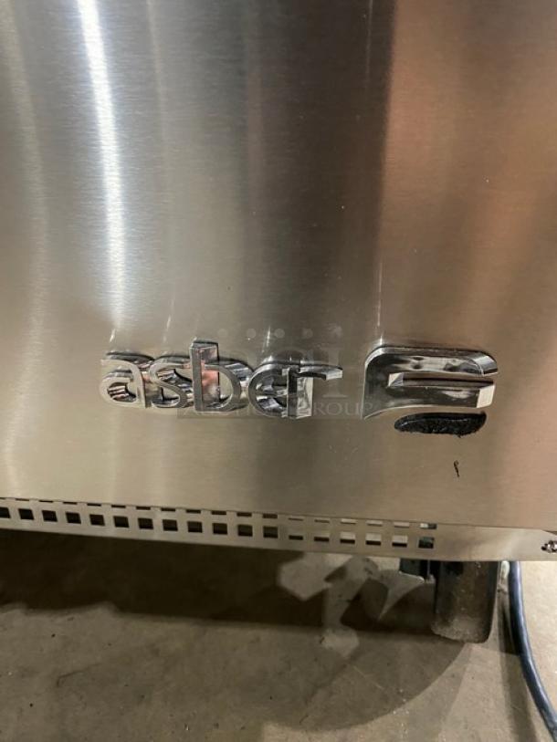 Asber logo on stainless steel panel of model APTS-72-18-HC salad prep table, 2021 model on casters.