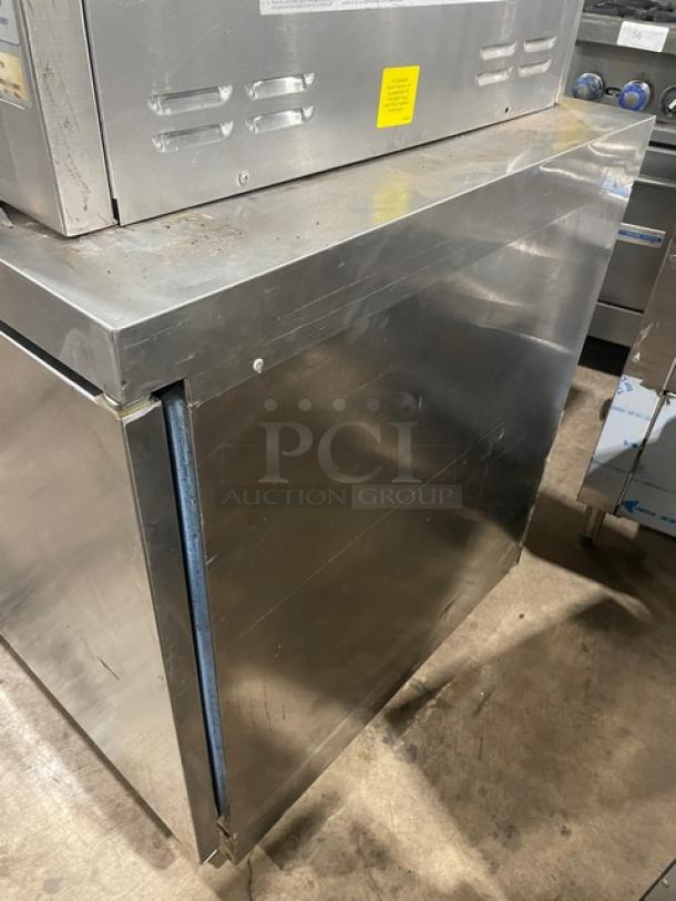 Delfield stainless steel under-counter refrigerator, single solid door, polly coated rack, on casters, used condition.