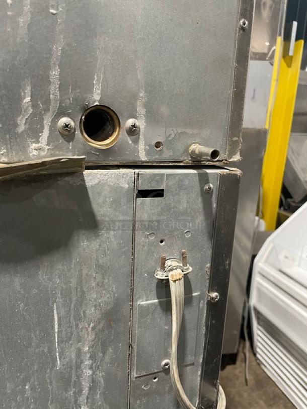 Hoshizaki stainless steel ice machine, model 30H KM-32MAH/DB-1, shows some surface wear, visible wiring, and air-cooled features.