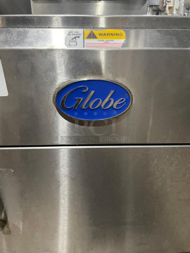 Globe commercial stainless steel countertop deep fat fryer with backsplash, basket hanger, and warning label.