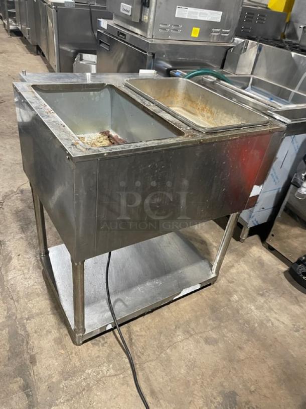Omcan 2019 stainless steel electric 2-bay hot food table, model FZ-06B1, with undershelf and legs, showing signs of use.