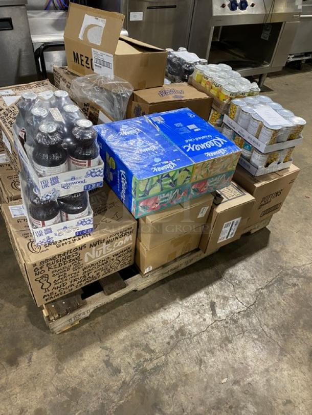 Mixed pallet of brand new items including Kleenex Commercial 2-ply tissues, assorted snack foods, and beverages. Boxes display logos and product labels.