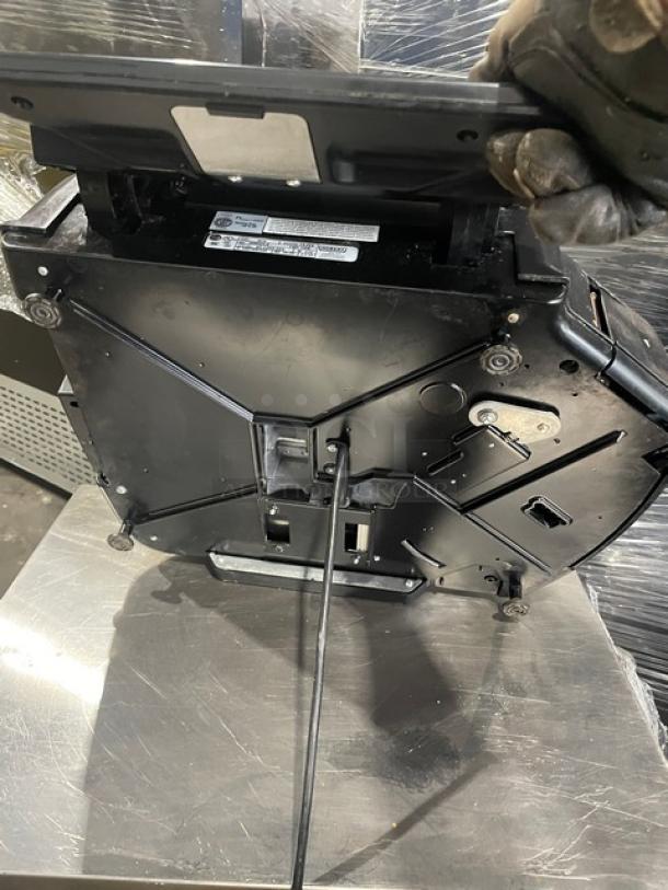 Hobart HTi black commercial scale with label printer, stainless steel platform, and visible serial number.
