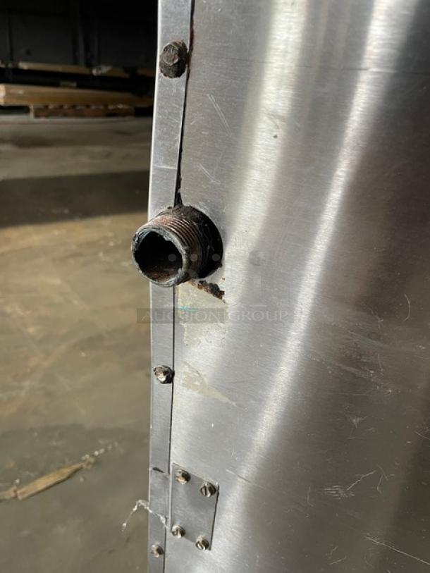 Close-up of Bakers Pride F60R stainless steel charbroiler side panel, showing a pipe fitting and riveted edges.