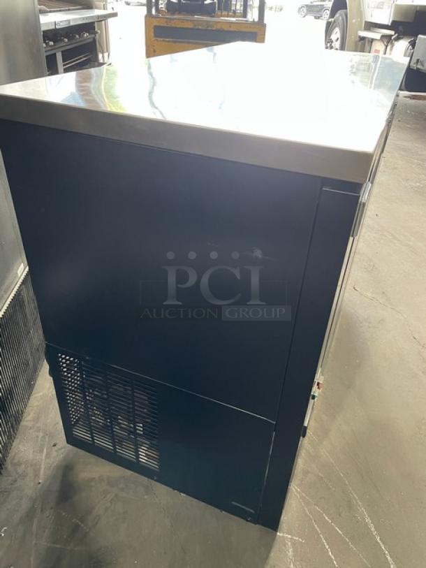 Kelvinator two-door 48" black back bar refrigerator, Model KCBB48SBHC, with stainless steel worktop and poly coated wire racks.