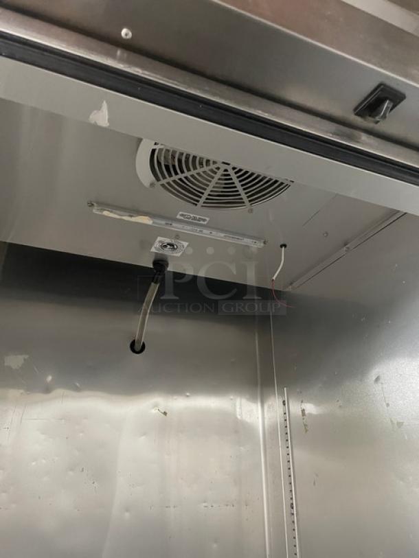 True T23HC single door stainless steel refrigerator interior, featuring poly-coated wire racks, model tag visible.