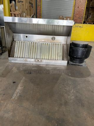 Commercial stainless steel kitchen exhaust hood with filter and electric exhaust fan. Some wear visible.
