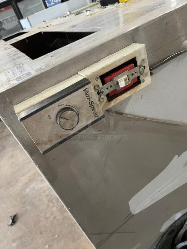 Commercial stainless steel kitchen exhaust hood with filter and electric exhaust fan. Features variable speed control.